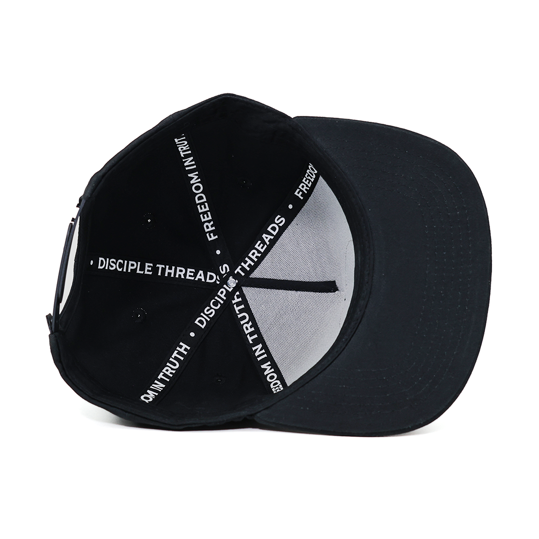 Black cap with white text and peace symbol on a white background