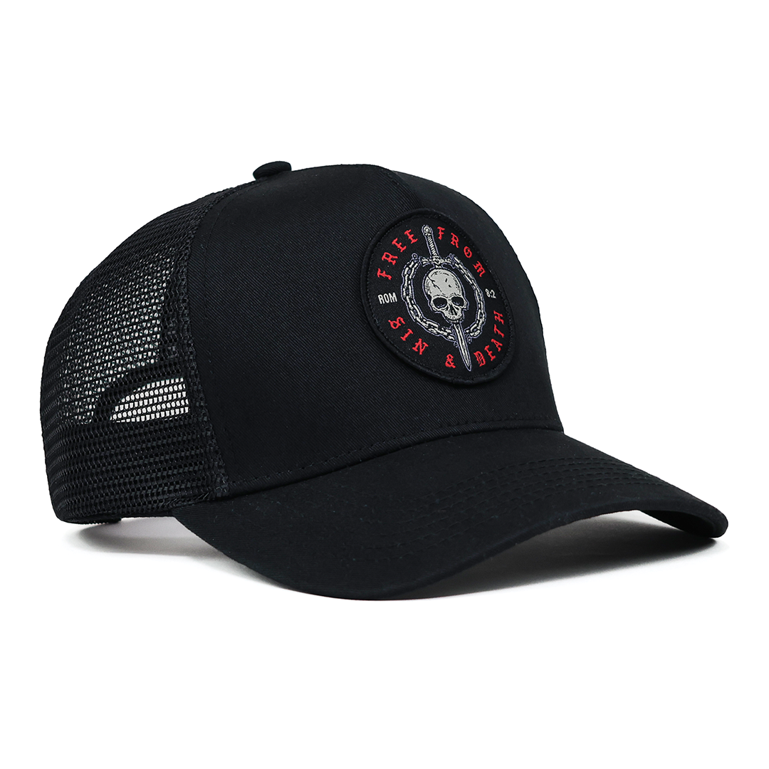 Black trucker cap with a skull and sword patch on a white background