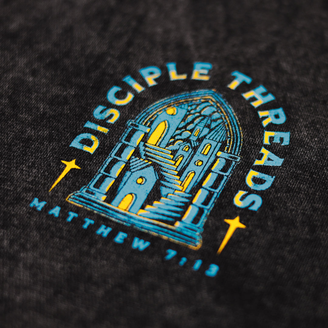Close-up of a black hoodie with blue and yellow graphic design and text.
