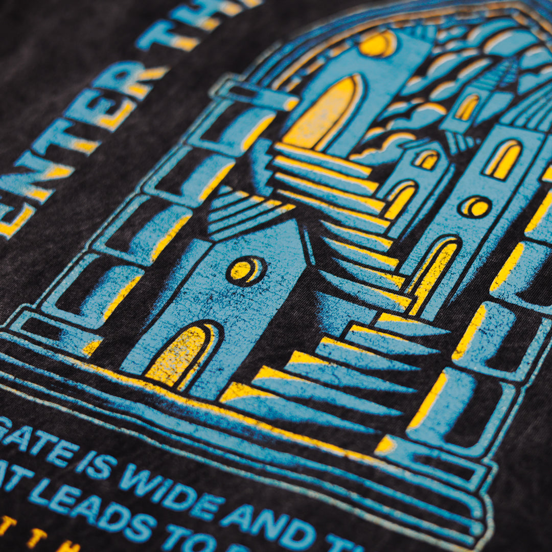 Close-up of a black t-shirt with blue and yellow graphic design and text.