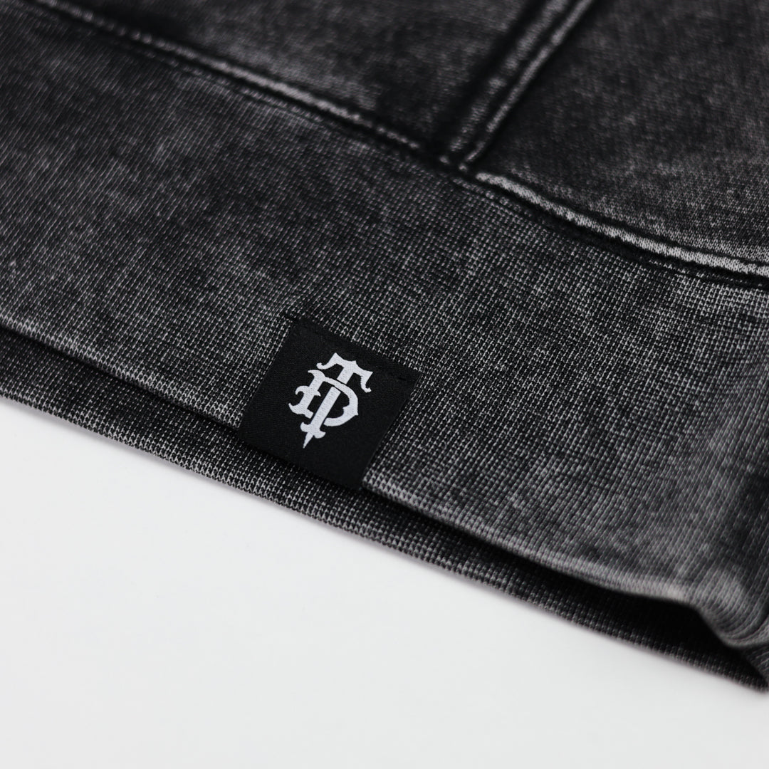 Close-up of a black label with a logo on black fabric.