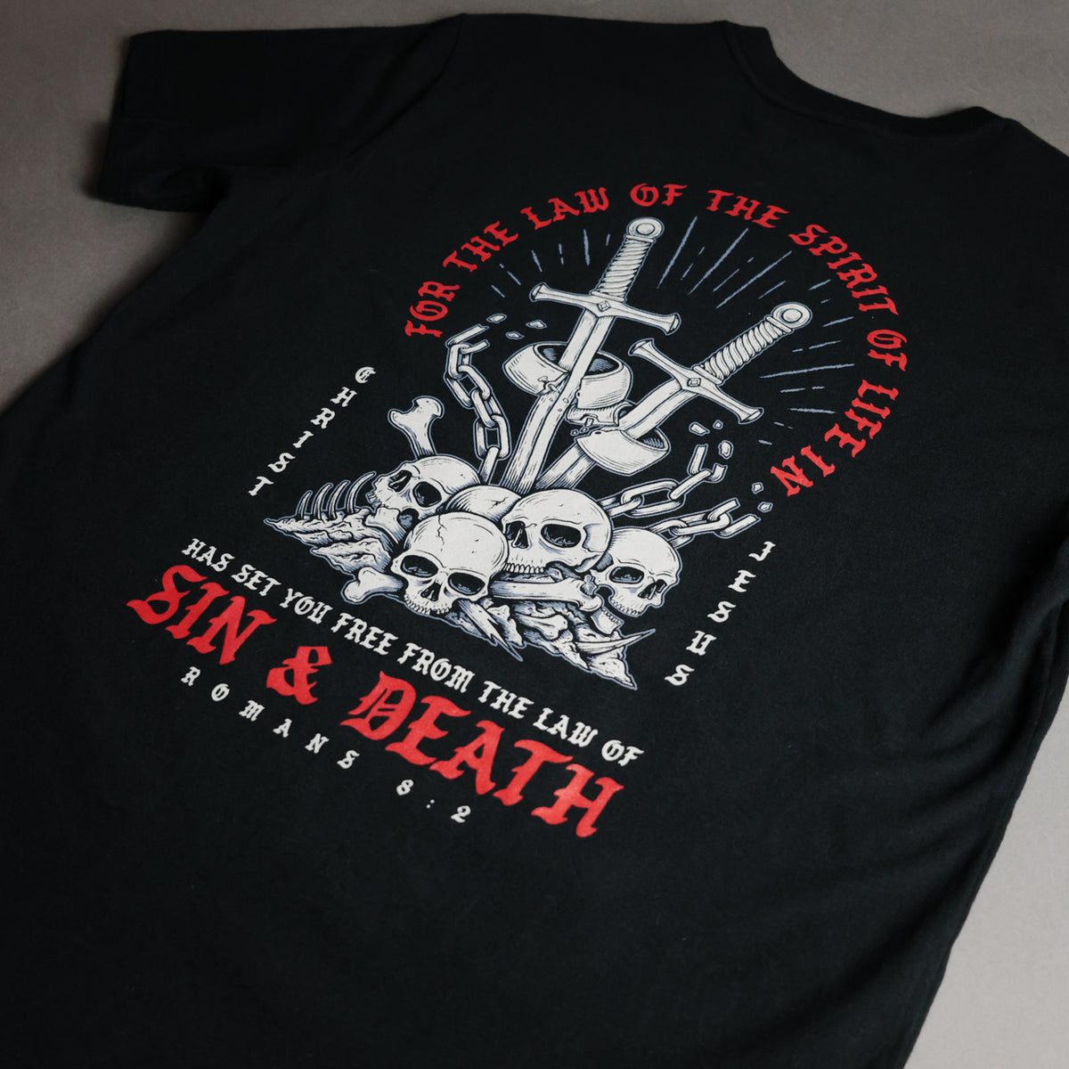 Black t-shirt with skull and crossbones design and text on a gray background