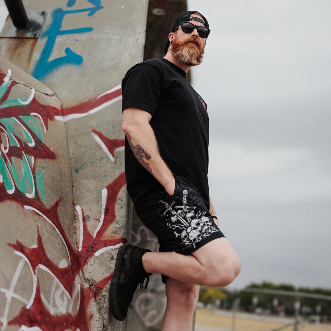 Man leaning against a graffiti-covered wall wearing bold Christian apparel.