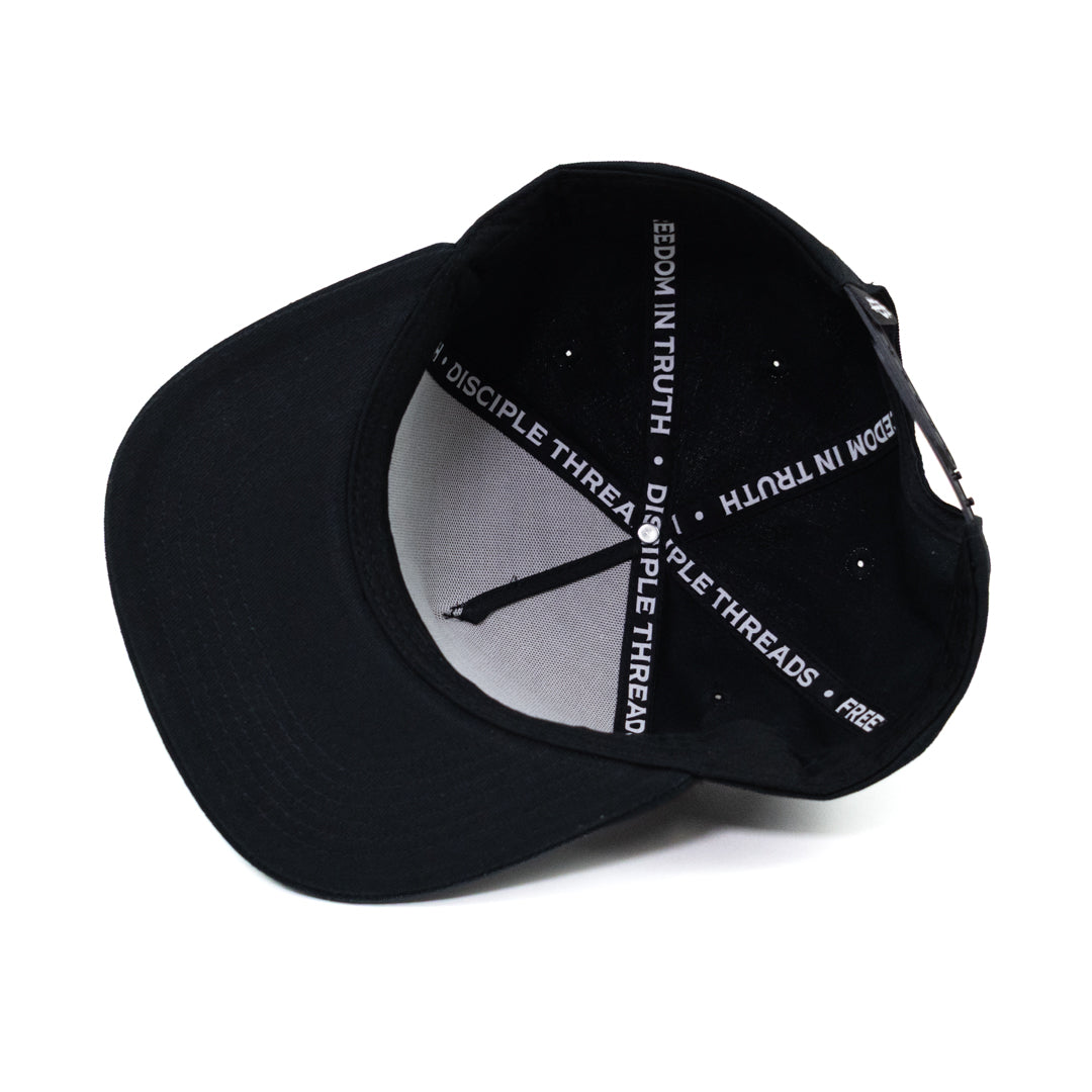 Inside of flat bill cap featuring taping that reads, "Disciple Threads" and "Freedom in Truth."