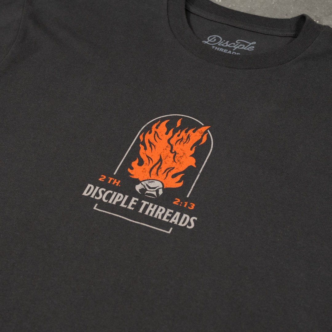 Close-up of the dark grey Sanctification T-shirt chest graphic, an orange flaming dove and coal in an arch above Disciple Threads, 2 Thessalonians 2:13.