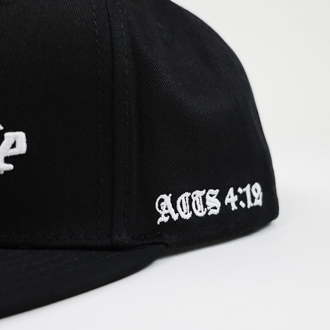 Black flat bill cap with 'Acts 4:12' text on a white background