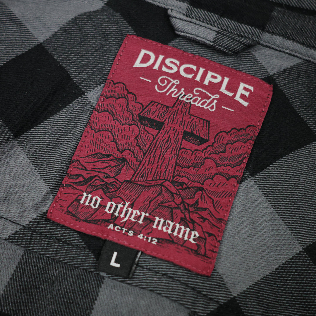 Red label with 'Disciple Threads' text on a flannel shirt
